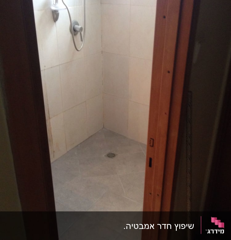 מקלחת עם אריחים חדשים וראש מקלחת מותקן